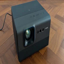 Front view of the BenQ GP520 4K projector on a wooden floor