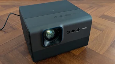 Front view of the BenQ GP520 4K projector on a wooden floor