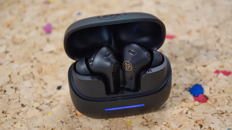 The JLab JBuds Pods ANC wireless earbuds in their charging case on a cork table