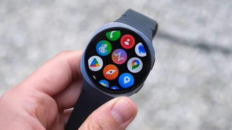 The Samsung Galaxy Watch 8 being held in a hand and displaying various Wear OS apps