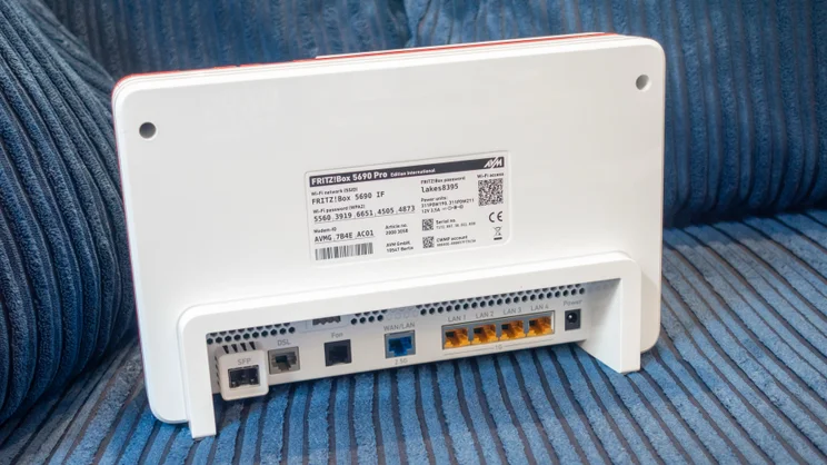 The AVM Fritz!Box-5690 Pro pictured from the rear on a blue sofa