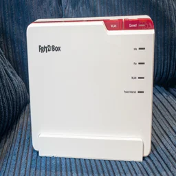 The AVM Fritz!Box5690-Pro pictured from the front on a blue sofa