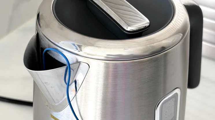 A close up of the Breville Edge Low Steam kettle's spout. A temperature probe is inserted into it.