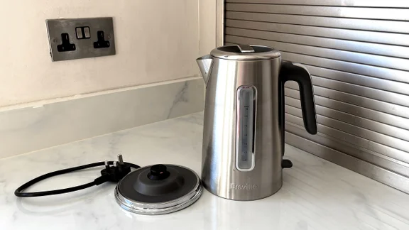 The Breville Edge Low Steam kettle on a kitchen worktop, alongside its base