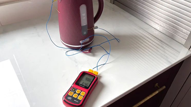 The Daewoo Cascade kettle on a kitchen worktop. A thermometer and temperature probes are being used to measure its internal and external temperatures