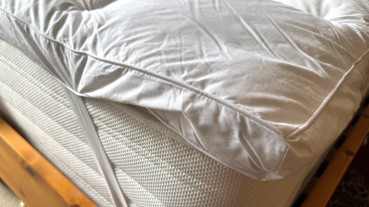 A closeup of the corner of the Dorma Full Forever mattress topper. Elasticated straps are holding it onto a mattress