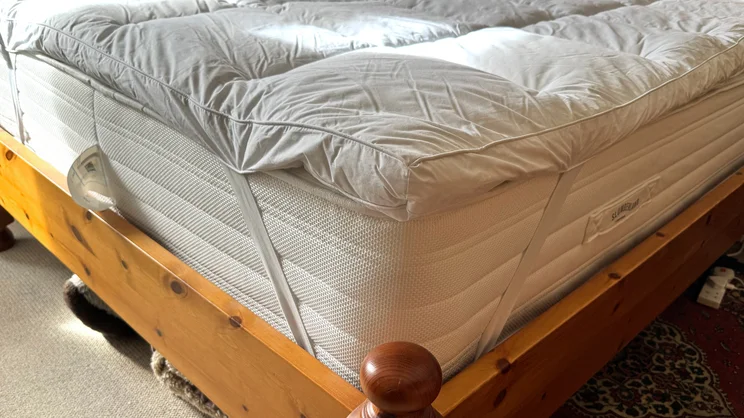 A closeup of the corner of the Dorma Full Forever mattress topper. Elasticated straps are holding it onto a mattress