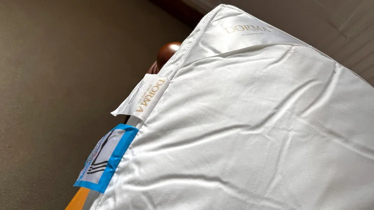 A closeup of the corner of the Dorma Full Forever mattress topper, showing branding and care labels