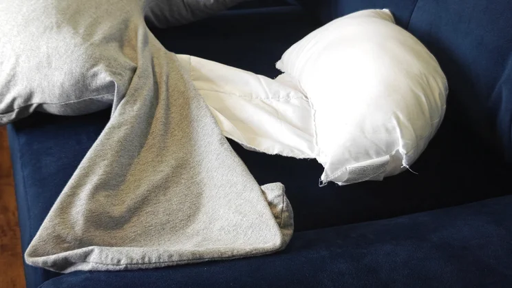 The Dreamgenii pregnancy pillow with its cover partially removed