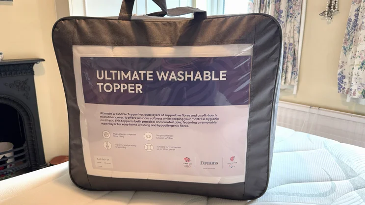 The Dreams Dream Team Ultimate Washable Mattress Topper in its carry bag on top of a mattress