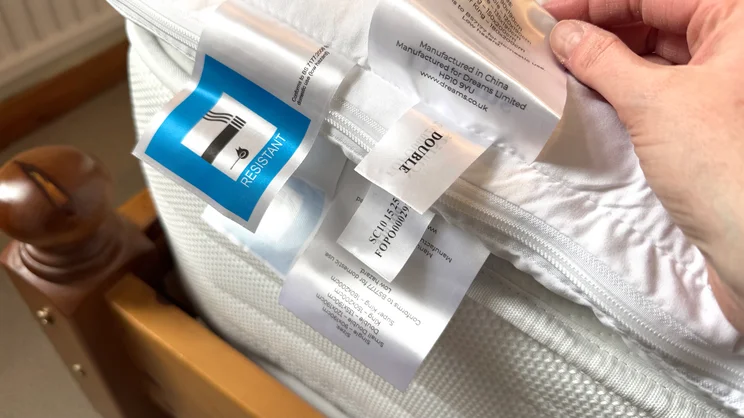 A closeup of the Dreams Dream Team Ultimate Washable Mattress Topper's care labels