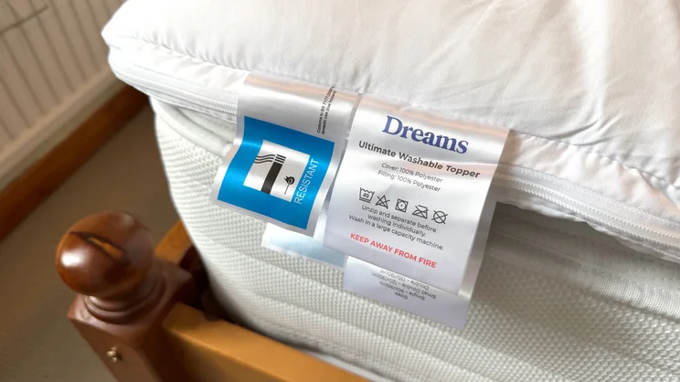 A closeup of the Dreams Dream Team Ultimate Washable Mattress Topper's care labels