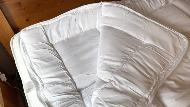 A closeup of the corner of the Dreams Dream Team Ultimate Washable Mattress Topper. The two layers have been unzipped and separated