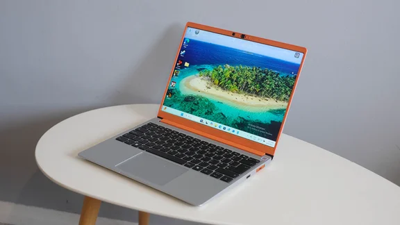 The Framework Laptop 13, open, pictured from the right front corner, on an oval white table