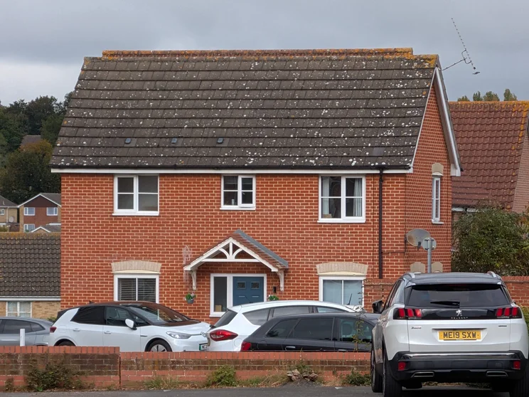 10x zoom of a house with cars parked outside