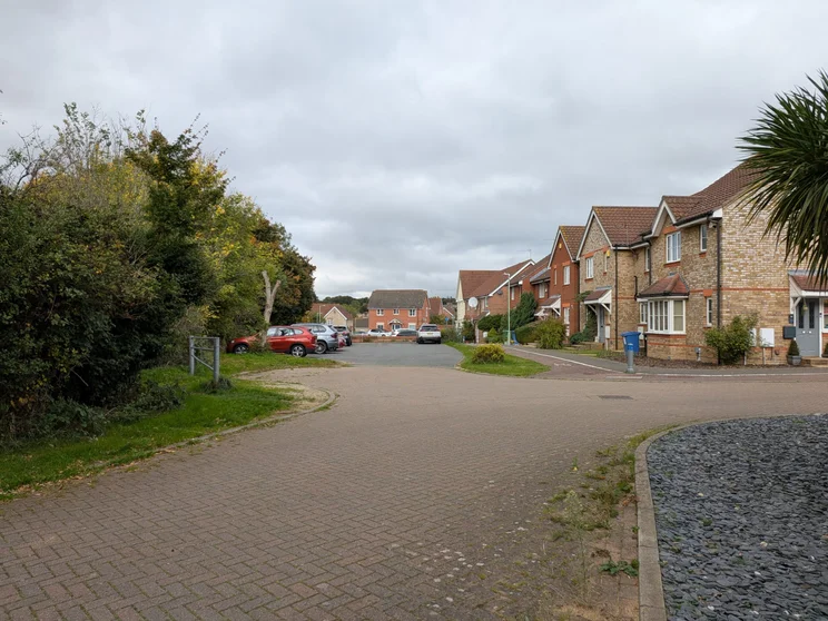 A quiet close of houses with cars parked outside