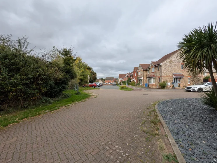 Wide-angle view of houses with cars parked outside