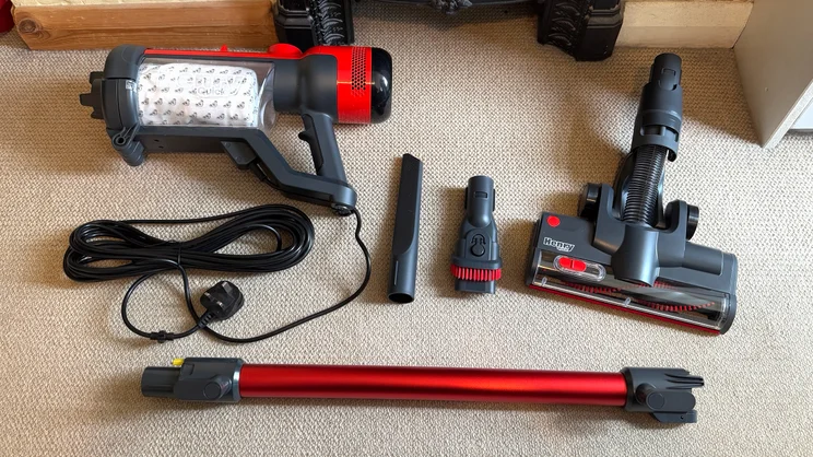 The parts of the Henry Quick Corded vacuum cleaner - including stick, floor head, crevice tools and canister - disassembled and laid out on the floor