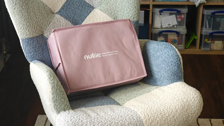 The Nuliie Pregnancy Pillow in its case, on a chair