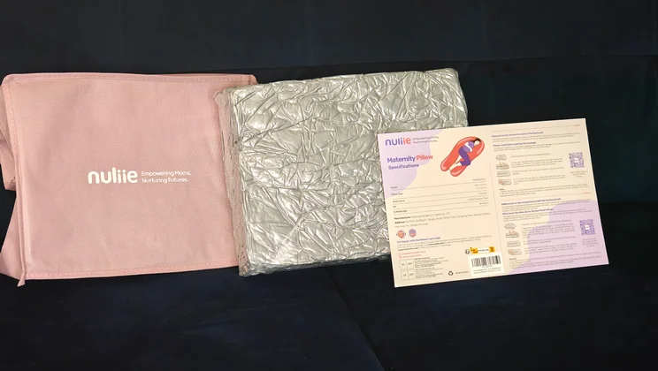 The Nuliie Pregnancy Pillow, vacuum packed, alongside its case and instructions