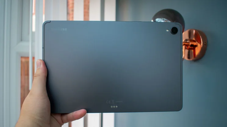 Hand holding the Samsung Galaxy Tab S11, rear view
