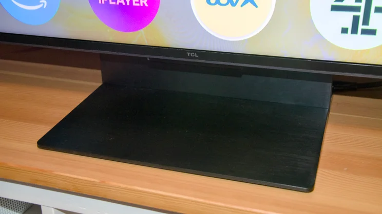 The centrally mounted stand of the TCL C7K, pictured from the front