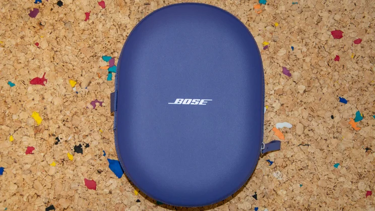 The carrying case of the Bose QuietComfort Ultra Headphones (2nd Gen) closed on a cork table