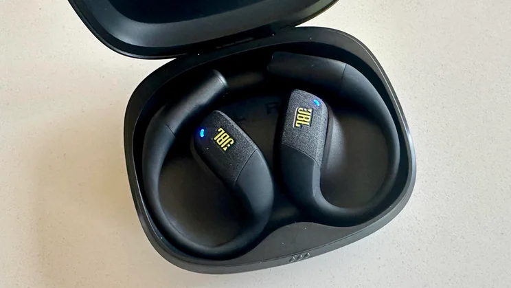The JBL Endurance Zone open-ear headphones inside their charging case with the case open