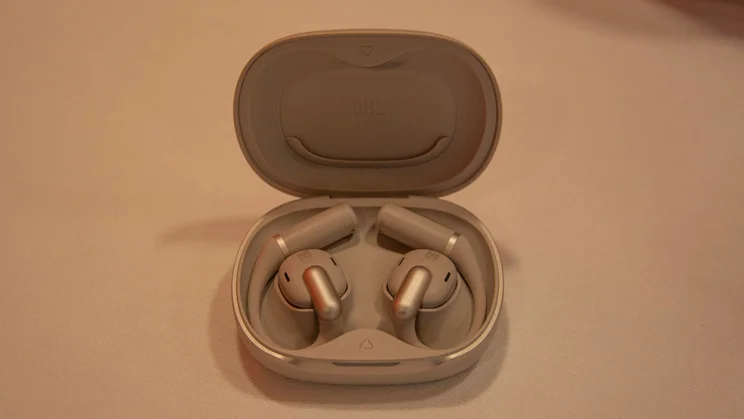 The JBL Sense Pro in their charging case with the lid open