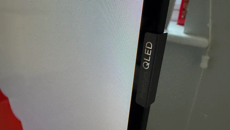 Close-up shot of the Premium QLED badge attached to the side of the TCL P7K QLED TV's panel