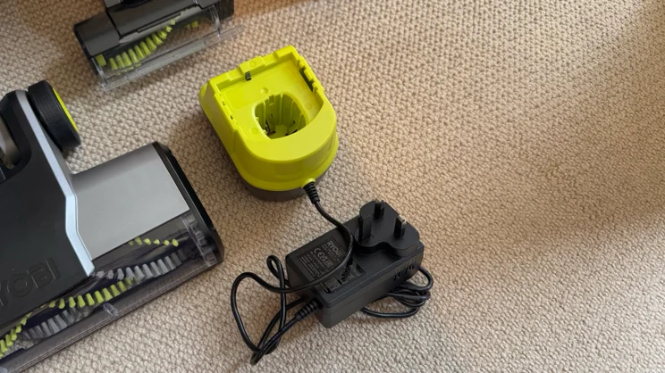 A photograph showing the Ryobi 18V ONE+ Cordless Stick's motorised heads and battery charger