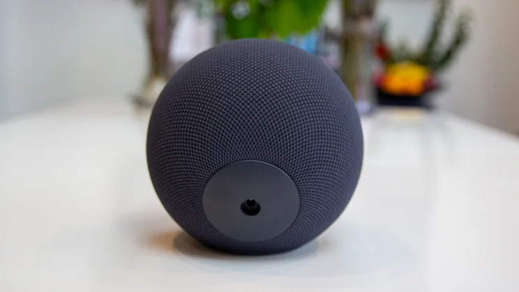 The Amazon Echo Studio 2025 pictured from the rear, disconnected from the mains, on a white dining table with flowers in the background