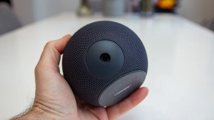 Amazon Echo Dot Max on a white table, photographed from the rear held in a hand