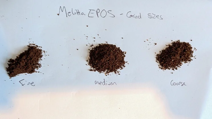 A bird's eye view of three small piles of ground coffee, lined up in a row and labelled 'Fine', 'Medium' and 'Coarse"
