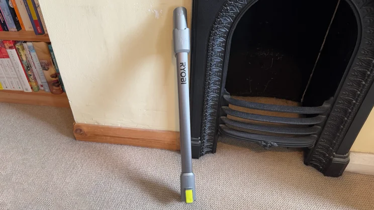 The Ryobi 18V ONE+ Cordless Stick's extension want leaning against a wall next to a cast iron fireplace