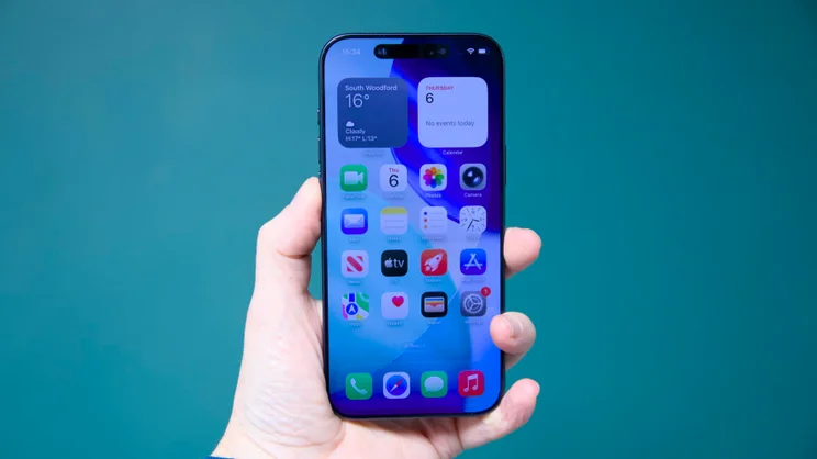 The Apple iPhone 17 Pro Max being held aloft with the screen facing outwards