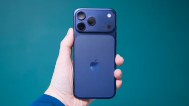 The Apple iPhone 17 Pro Max being held aloft with the rear cameras facing outwards