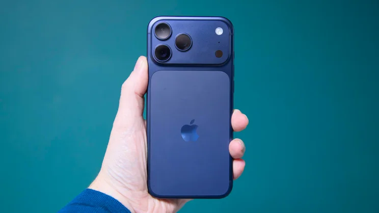 The Apple iPhone 17 Pro Max being held aloft with the rear cameras facing outwards