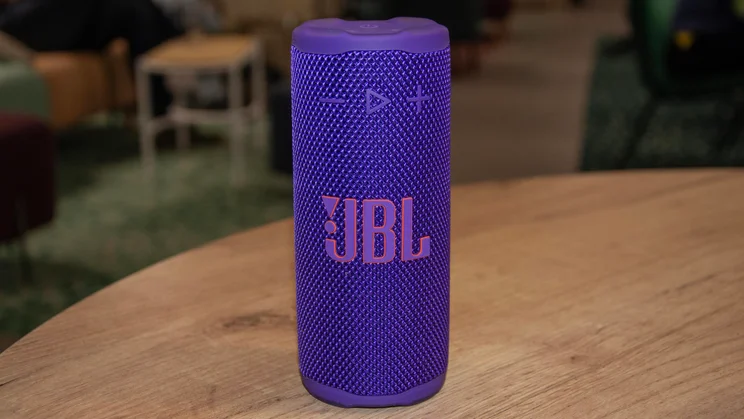 The JBL Grip portable Bluetooth speaker stood up vertically on a wooden table