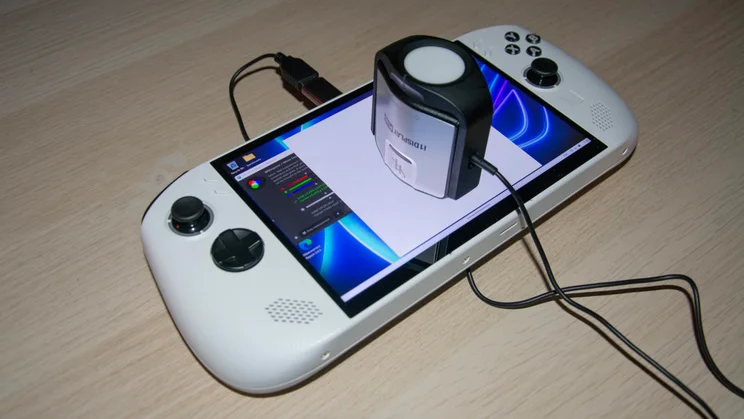 The Lenovo Legion Go S with a colorimeter on the screen testing colour accuracy and brightness
