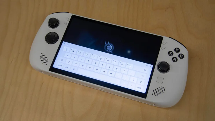 The Lenovo Legion Go S on a wooden table with the pop-up keyboard displayed