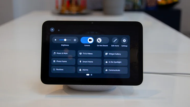 The Amazon Echo Show 8 (4th gen, 2025) pictured from the front on a white table, showing shortcut buttons