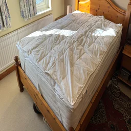 The Dusk Supreme Goose Down mattress topper on a mattress in a bedroom