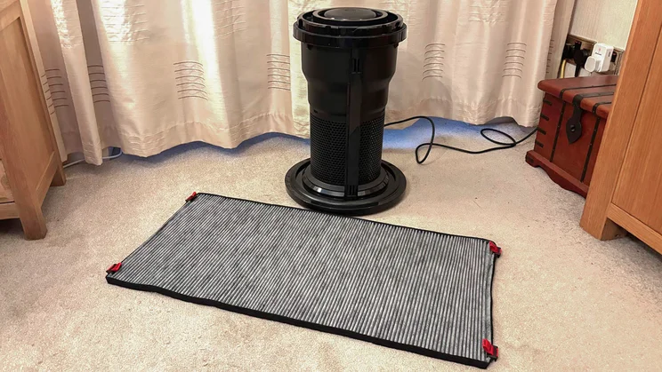 The Dyson Big+Quiet Formaldehyde air purifier's core unit, alongside the carbon filter laid flat on the floor in a living room
