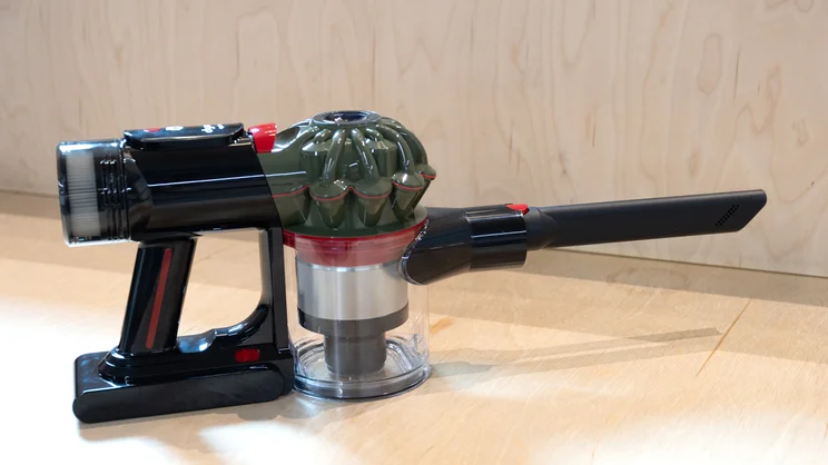 The Dyson V8 Cyclone vacuum cleaner handle on an office bench, with crevice tool attached