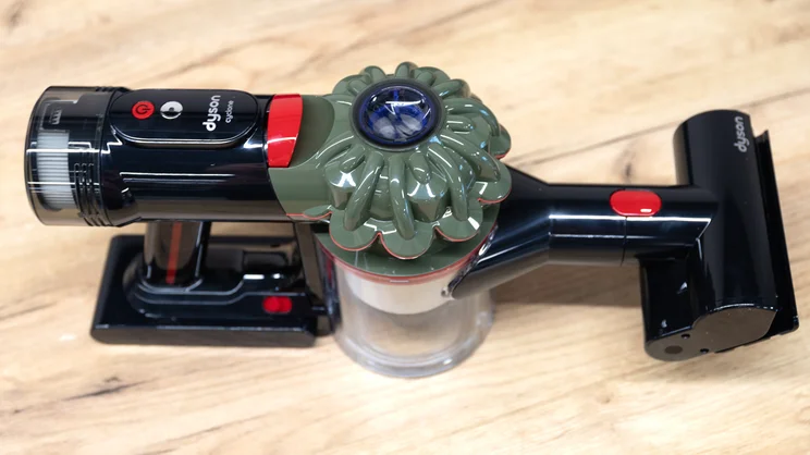 The Dyson V8 Cyclone vacuum cleaner handle on an office table, with mini motorised tool attached