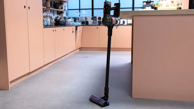 The Dyson V8 Cyclone vacuum cleaner leaning against a kitchen island in an office