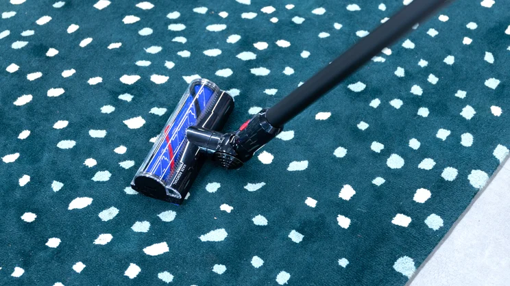 The Dyson V8 Cyclone on a speckled carpet