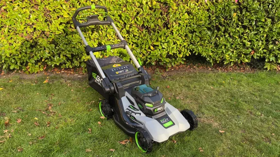 The Ego LM2236E-SP lawn mower on a lawn, in front of a hedge