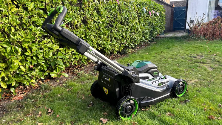 The LM2236E-SP lawn mower on a lawn in front of a hedge